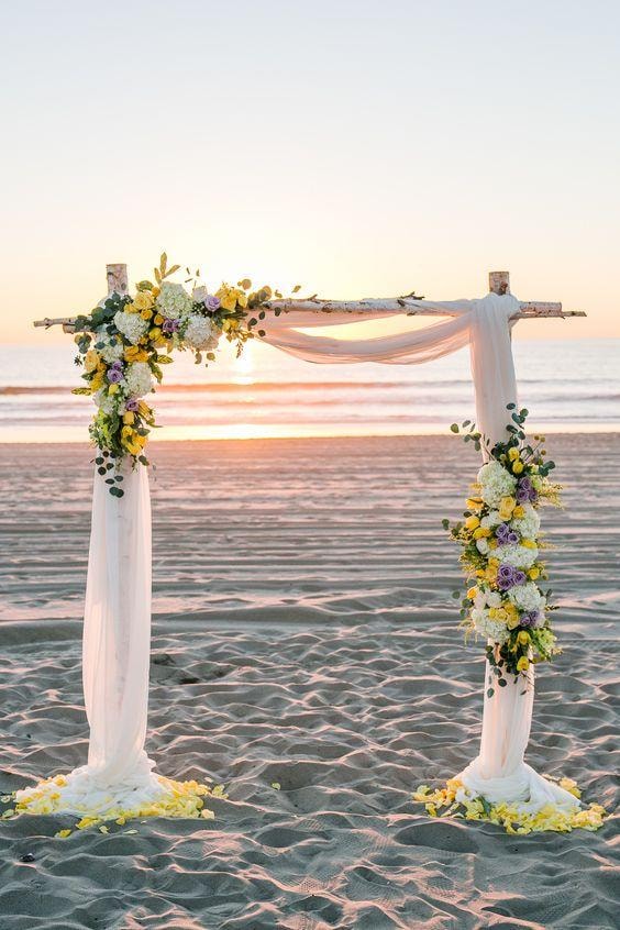 Beach wedding ceremony arch at sunset